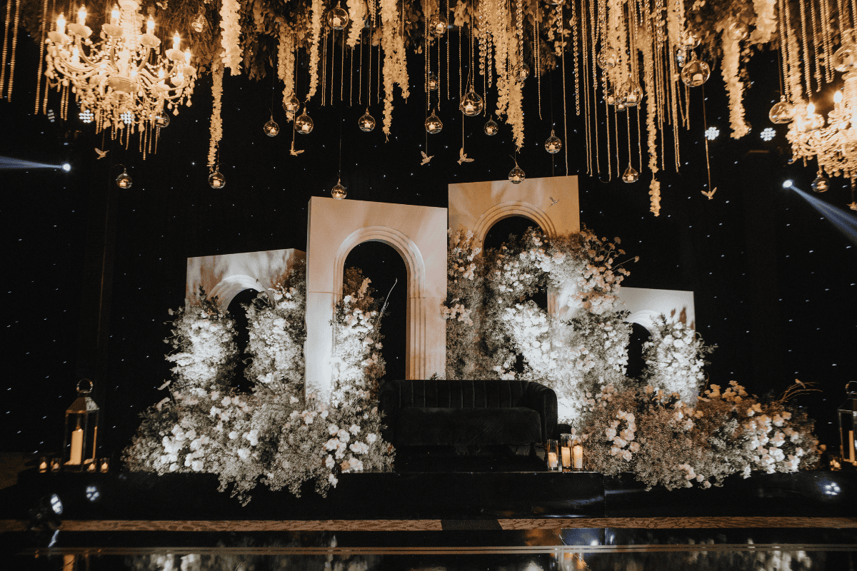 Luxurious wedding reception stage backdrop with chandelier lighting styled by Beloved Planners, captured by PTaufiq Photography