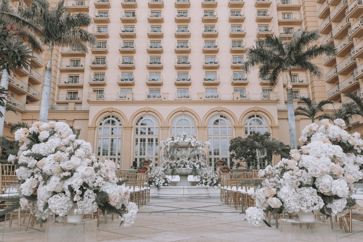 Elegant wedding aisle setup by Electric Karma International, featuring floral arrangements and lighting.